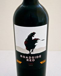 A bottle of Roadside Red wine from Lodi Winegrape Commission with a dinosaur illustration on the label.