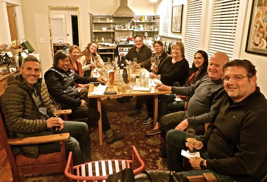 Group of people enjoying a dinner gathering at a cozy restaurant, celebrating Lodi wine and local winegrowers.