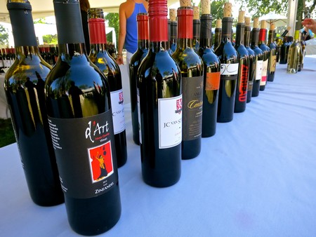 Lineup of wine bottles from Lodi Winegrape Commission on a table for tasting event.
