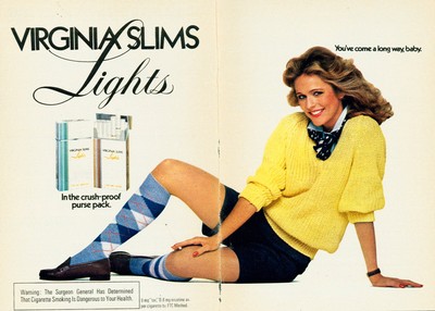 Vintage Virginia Slims Lights cigarette pack ad featuring a smiling woman in a yellow sweater and patterned knee-high socks.