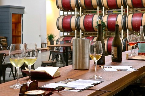 Wine glasses, bottles, and barrels at a wine tasting event in Lodi, California.