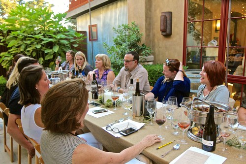Group of people enjoying wine tasting outdoors at Lodi Winegrape Commission event.