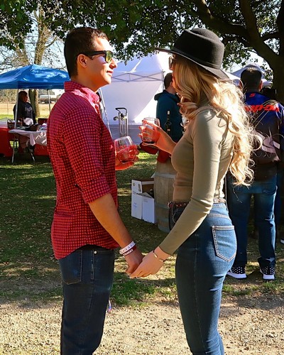 Couple enjoying wine tasting at Lodi Winegrape Commission outdoor event.
