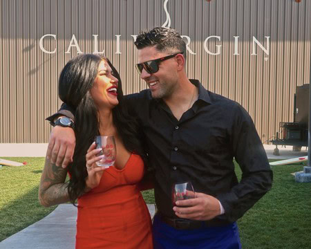 Two people enjoying wine at a Lodi Winegrape Commission event outdoors.