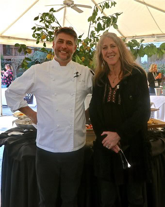 Chef and woman smiling at Lodi Winegrape Commission event under a tent.