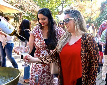 Women enjoying wine tasting at a Lodi Winegrape Commission event outdoors.
