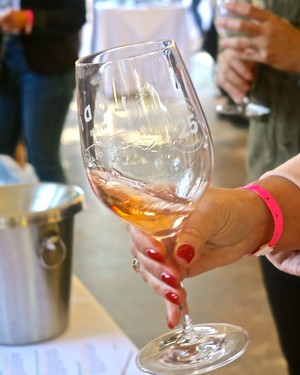 Person holding a glass of rosé wine at a wine tasting event in Lodi, California.