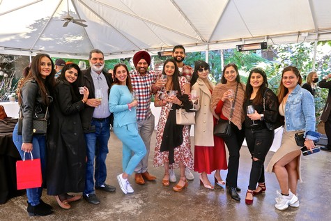 Group of diverse people enjoying a wine tasting event under a canopy at Lodi Winegrape Commission.