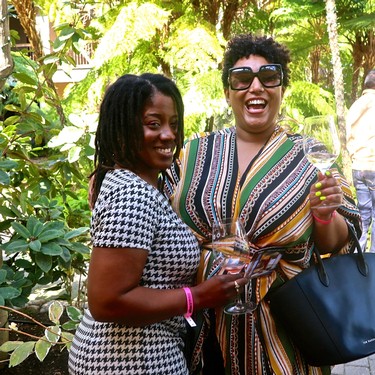 Two women enjoying wine at a Lodi Winegrape Commission event outdoors.
