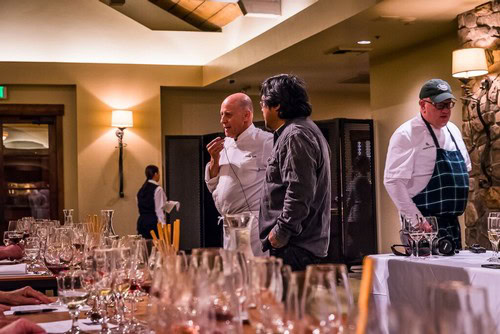 People tasting wine at a Lodi Winegrape Commission event in a cozy restaurant setting.