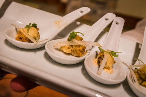 Three white ceramic tasting spoons with gourmet food samples for wine pairing at Lodi Winegrape Commission event.
