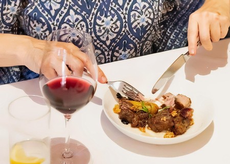 Person enjoying a gourmet meal with wine at Lodi Winegrape Commission event.