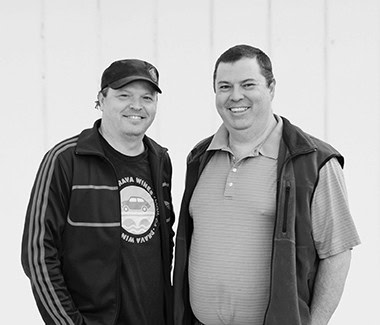 Two smiling men standing together, casual attire, at Lodi Winegrape Commission event.