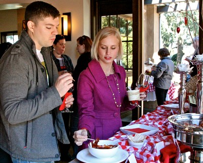 People enjoying wine tasting at Lodi Winegrape Commission event in a cozy indoor setting.