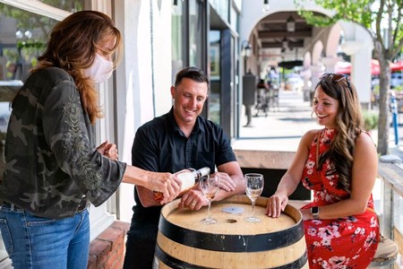 People enjoying wine tasting outdoors at a winery in Lodi, California.