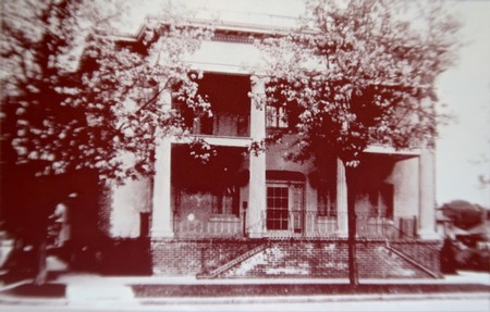 Old black and white photo of the historic Lodi Winegrape Commission building with trees and a porch.