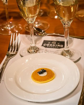 Glass of white wine and gourmet appetizer on a table at Lodi Winegrape event.