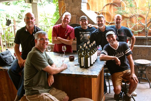 Group of wine industry professionals at Lodi Winegrape Commission event, smiling around a wine tasting table.