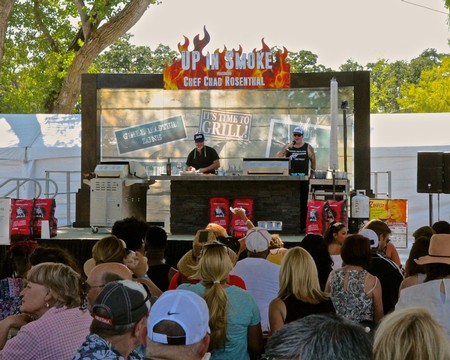 Outdoor event stage with chefs and audience, promoting Lodi wine and food festival activities.