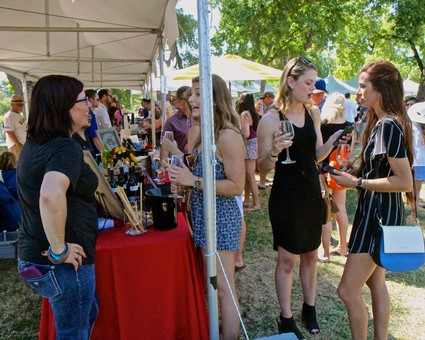 People enjoying wine tasting at the Lodi Winegrape Commission outdoor event.