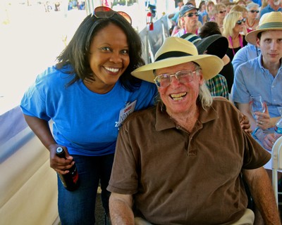 Smiling woman and elderly man at Lodi Winegrape Commission event, enjoying outdoor wine tasting.