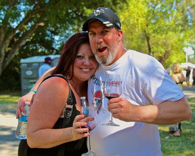 Happy couple enjoying wine at Lodi Winegrape Commission outdoor event.