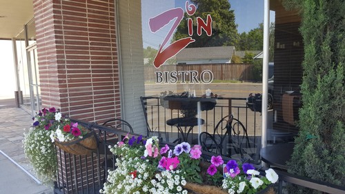 Exterior view of Zin Bistro with flower planters and outdoor seating area.
