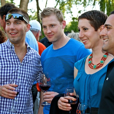 Group of people enjoying wine tasting outdoors at a Lodi Winegrape Commission event.