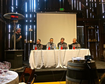 Panel discussion at Lodi Winegrape Commission event with four speakers and audience in a modern venue.