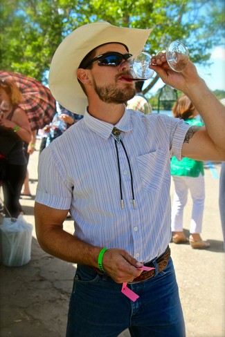 Man in cowboy hat and sunglasses drinking wine at Lodi Winegrape Commission event.