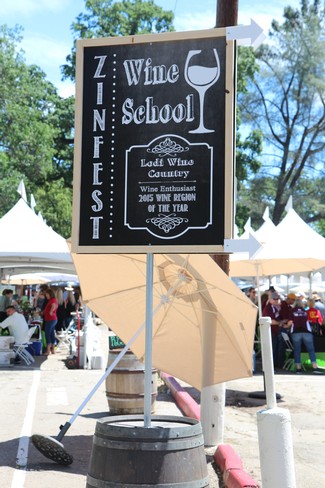 Lodi Wine School sign promoting wine education and celebrating Lodi Wine County with a wine glass graphic and event details.