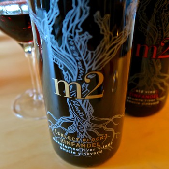 Close-up of a wine bottle with a blue tree design and 'm2' label, representing Lodi wine industry.