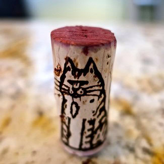 Cork with a hand-drawn cat illustration, representing Lodi Winegrape Commission branding.