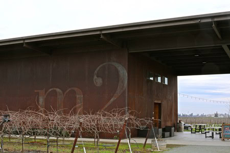 Vineyard with grapevines and a modern building at Lodi Winegrape Commission.