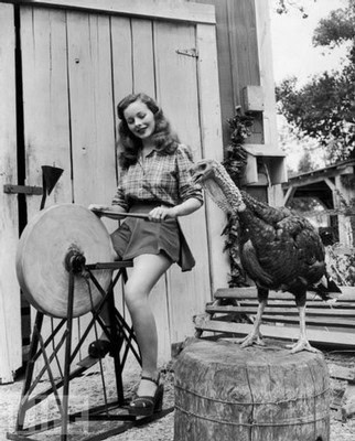 Black and white photo of a girl with a rooster and a millstone, vintage outdoor scene, nostalgic atmosphere.