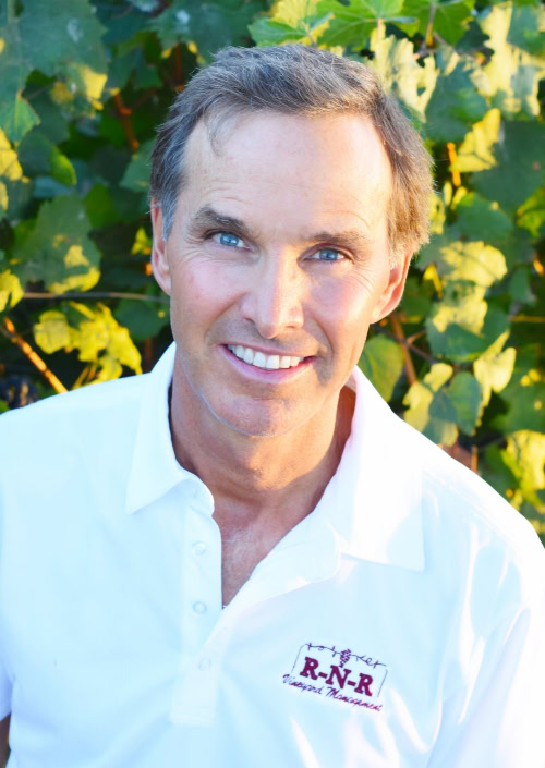Portrait of a man in a vineyard, representing Lodi Winegrape Commission and wine industry expertise.