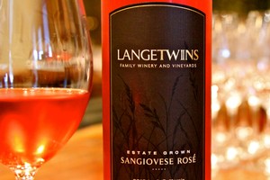 Bottle of Sangiovese Rosé wine from Lodi Winegrape Commission with a glass of rosé in the background.