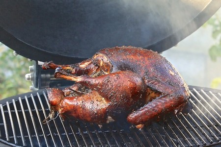 Juicy whole duck being grilled on a barbecue, perfect for wine pairing at Lodi Winegrape Commission event.